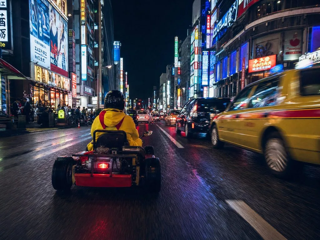 Night run through Shinjuku — neon signs from kart-driver height.
